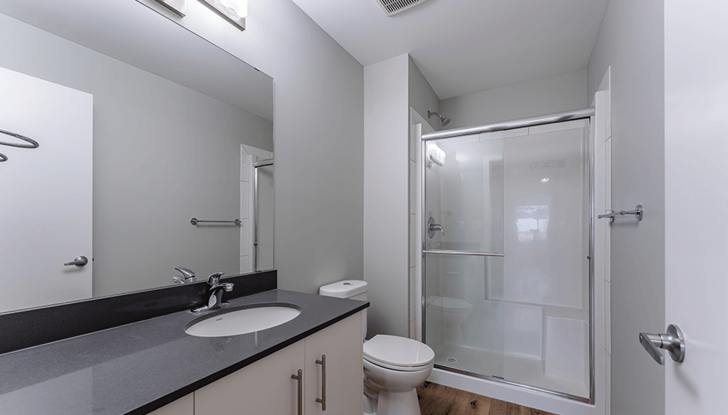 A bathroom with a sink, toilet, and shower.