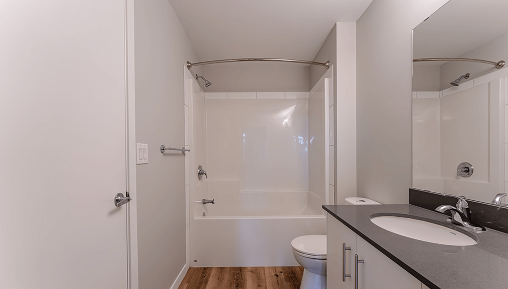 A bathroom with a toilet, sink, and shower.