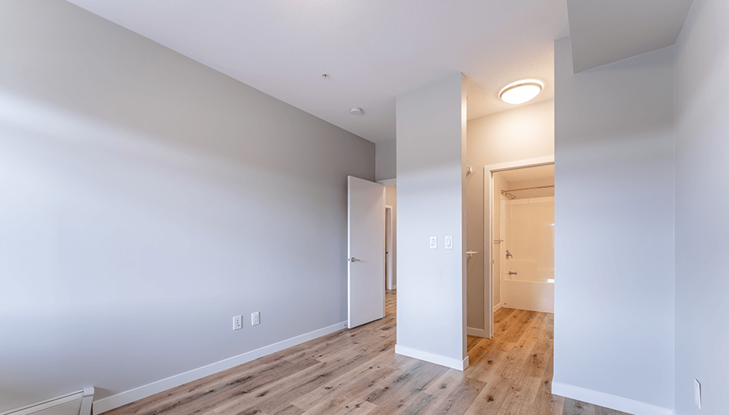 A white room with a doorway leading to another room.