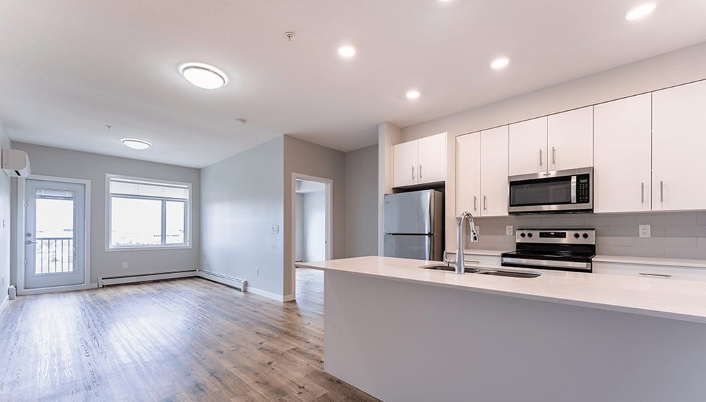 A modern kitchen with white cabinets and appliances.