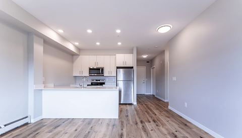 A kitchen with a refrigerator, microwave, and oven.