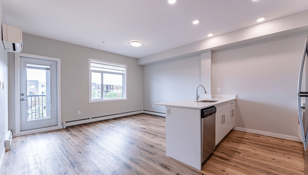 A kitchen with a white counter and wooden floors.