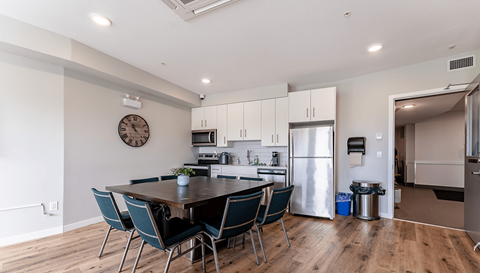 A modern kitchen with a dining table and chairs.