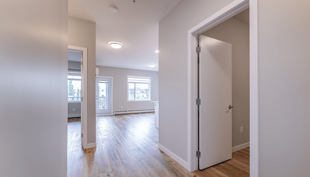 A room with a white door and a window.