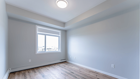 A room with a window and wooden flooring.