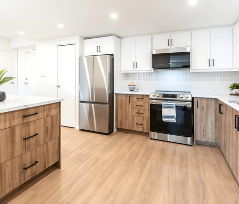 A kitchen with wooden cabinets and a stainless steel refrigerator.