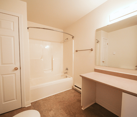 A white bathroom with a toilet, sink, and bathtub.