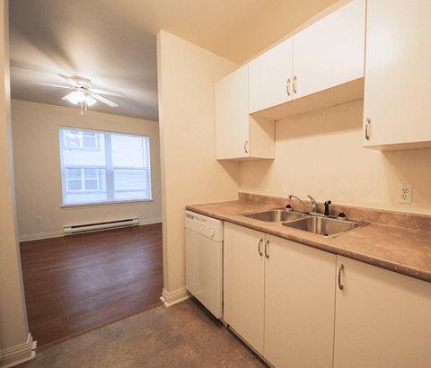 A kitchen with white cabinets and a window.