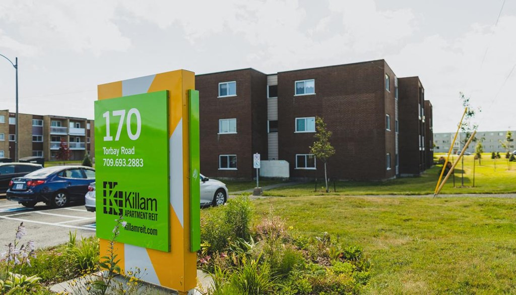 A green and white sign with the number 170 on it in front of a building.