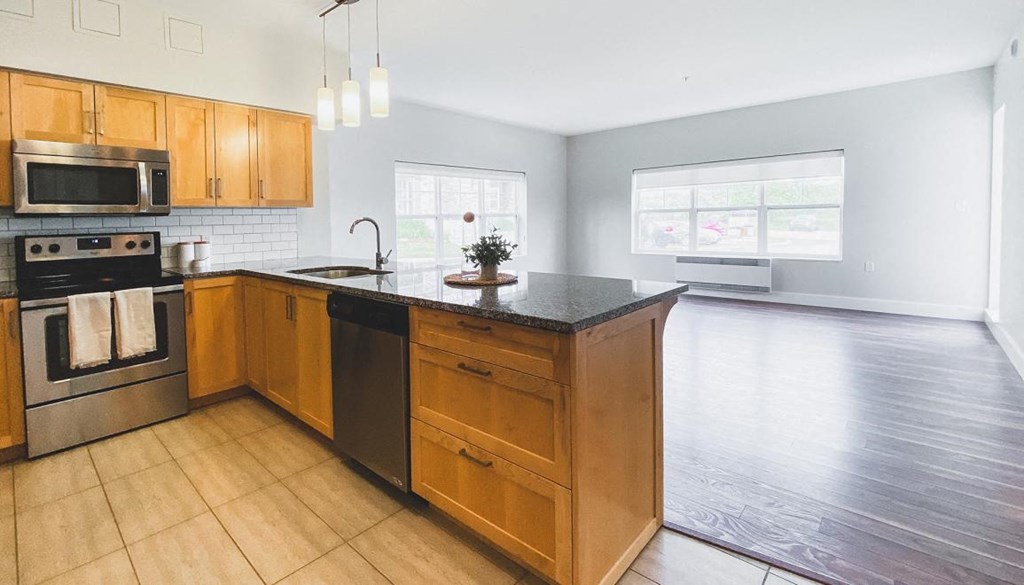 A kitchen with wooden cabinets and a black countertop.