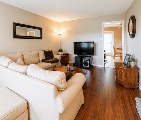 A living room with a white couch and a television.