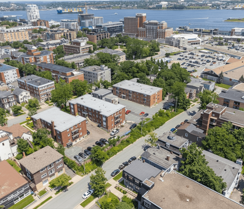 A bird's eye view of a city with buildings, cars, and a body of water.
