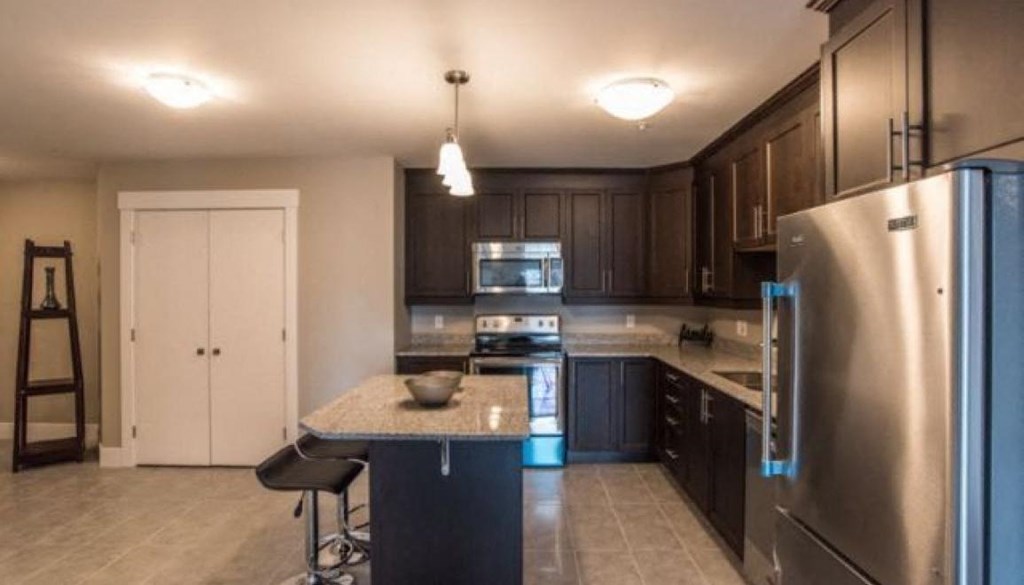 a kitchen with stainless steel appliances and black cabinets