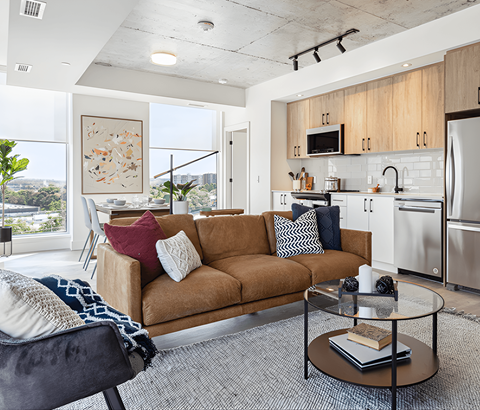 A modern living room with a brown sofa and a glass coffee table.