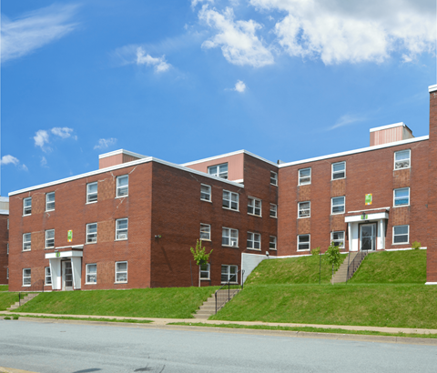 A red brick building with a green sign on the front.