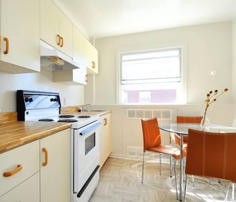 A kitchen with a stove, oven, and table.