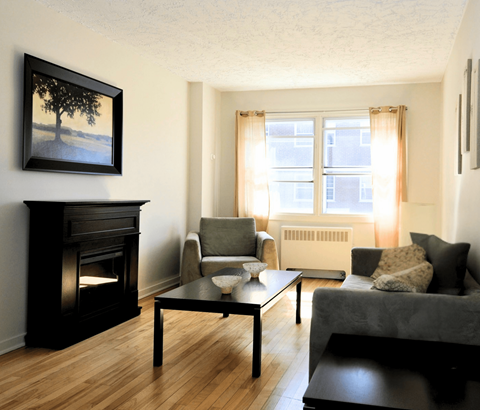 A living room with a fireplace and a painting on the wall.
