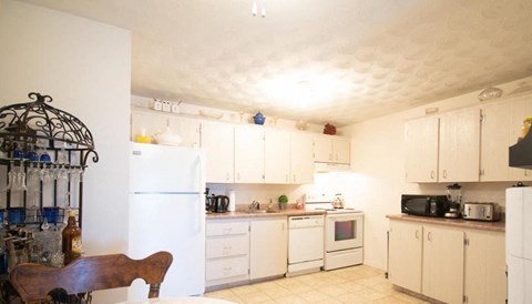 A kitchen with white cabinets and appliances.