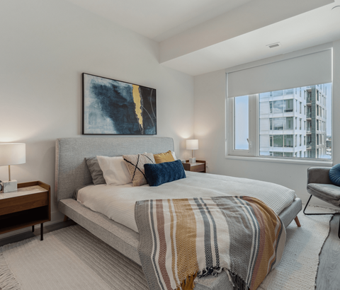 A bedroom with a large bed and a painting on the wall.