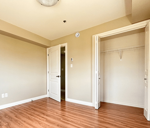 A room with a white door and a wooden floor.