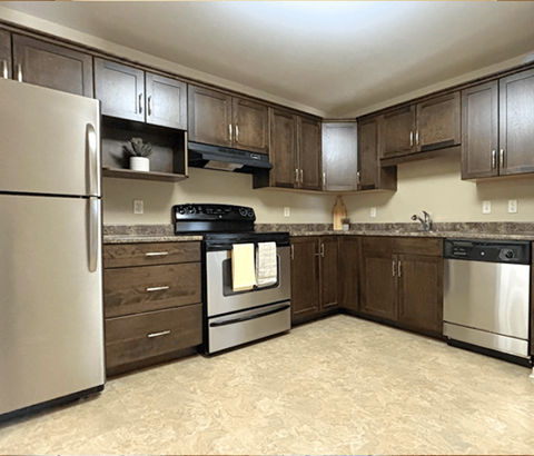 A kitchen with a refrigerator, oven, and sink.