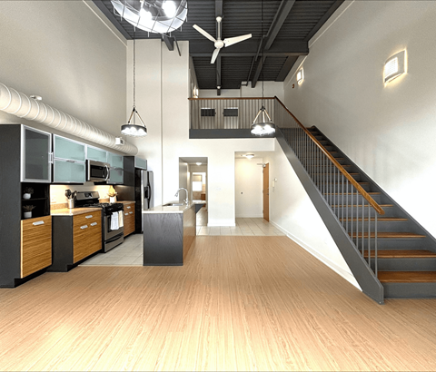 A modern kitchen with a staircase leading to the upper floor.