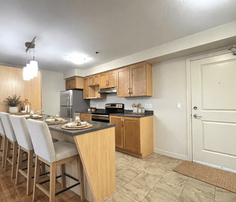 A kitchen with wooden cabinets and a black countertop.