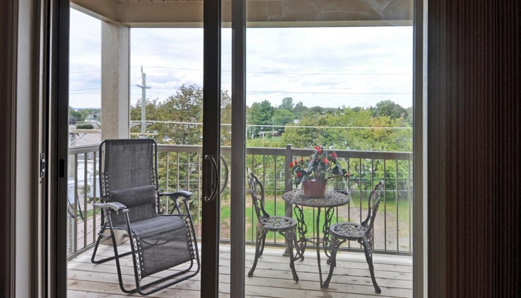 a patio with chairs and a table on a balcony