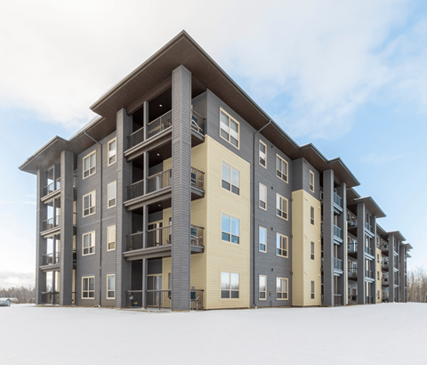 A large apartment building with balconies and multiple stories.