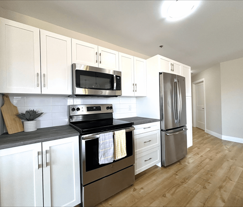 A kitchen with white cabinets and stainless steel appliances.