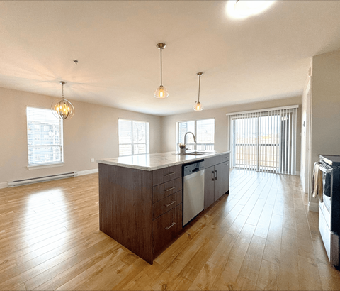 A kitchen with wooden floors and a large island with a sink.