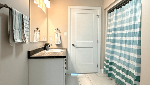 a bathroom with a sink and a shower and a door