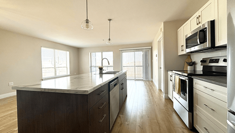 a kitchen with an island and a stove and a microwave