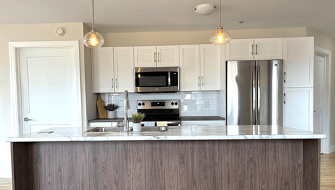 a modern kitchen with white cabinets and stainless steel appliances