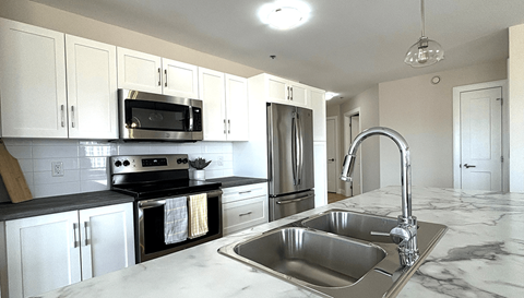 a kitchen with stainless steel appliances and marble counter tops