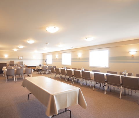 A conference room with a long table and chairs.