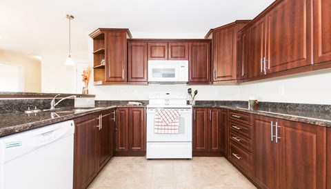 A kitchen with brown cabinets and a white stove top oven.