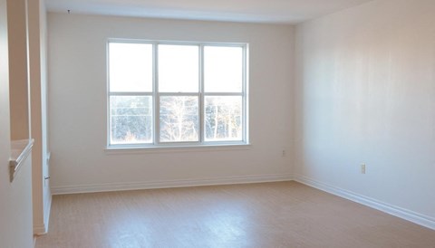 an empty living room with a large window