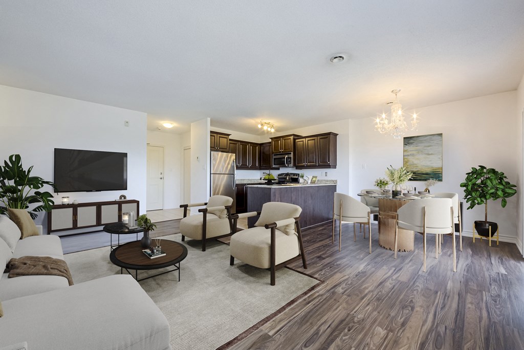a living room with couches and chairs and a kitchen with a tv