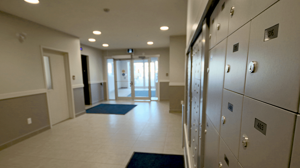 a hallway with lockers and a door to a locker room