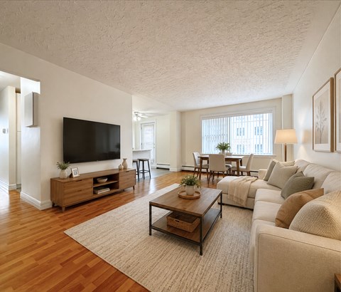 A living room with a white couch, a wooden coffee table, and a flat-screen TV.