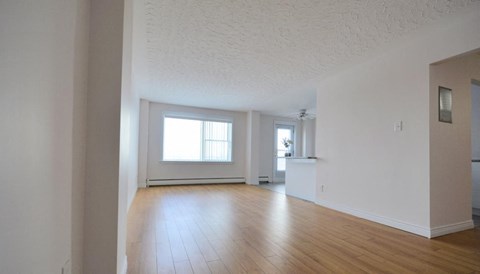 A large empty room with wooden floors and white walls.