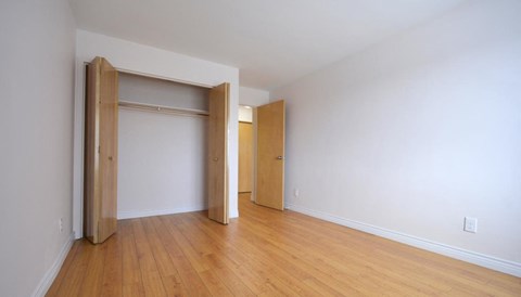 A room with a sliding door and wood flooring.
