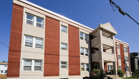 A red brick building with a white trim and windows.