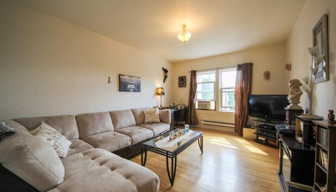A living room with a couch, coffee table, and a television.
