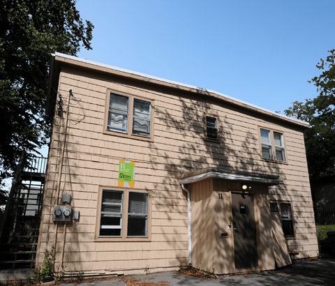 A small building with a green sign on it.