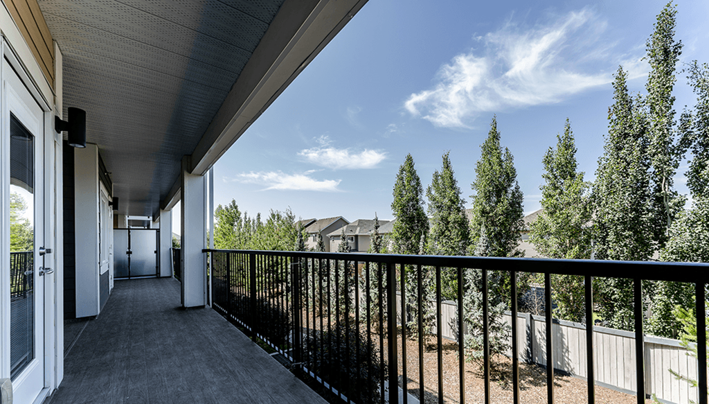 A balcony with a black railing and a view of a residential area.