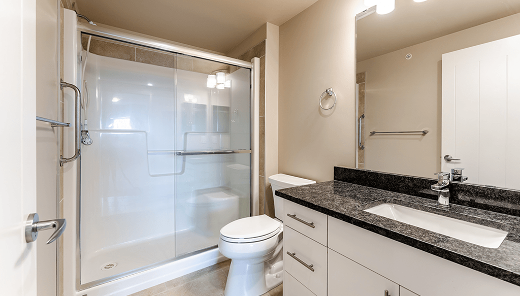 A bathroom with a toilet, sink, and shower.