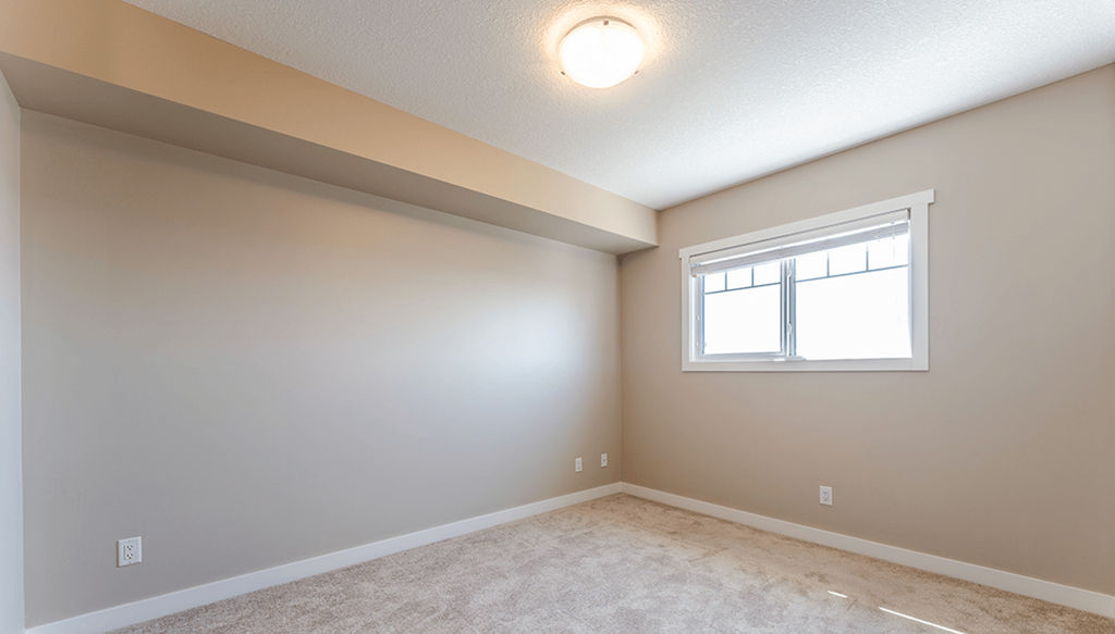 A room with a window and carpeted floor.