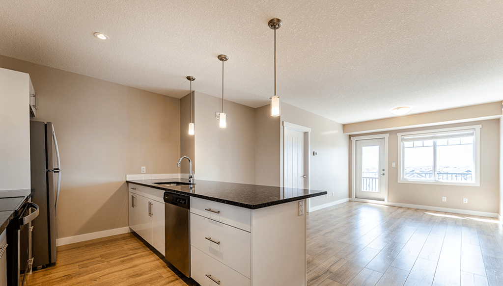 A kitchen with a black countertop and white cabinets.